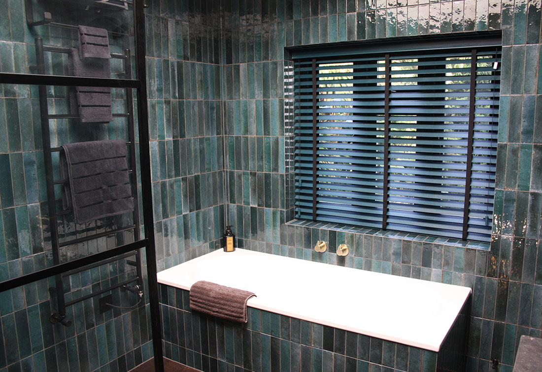 A luxury bathroom in West London with stunning tiles in masculine colours by interior designer Suzi Searle