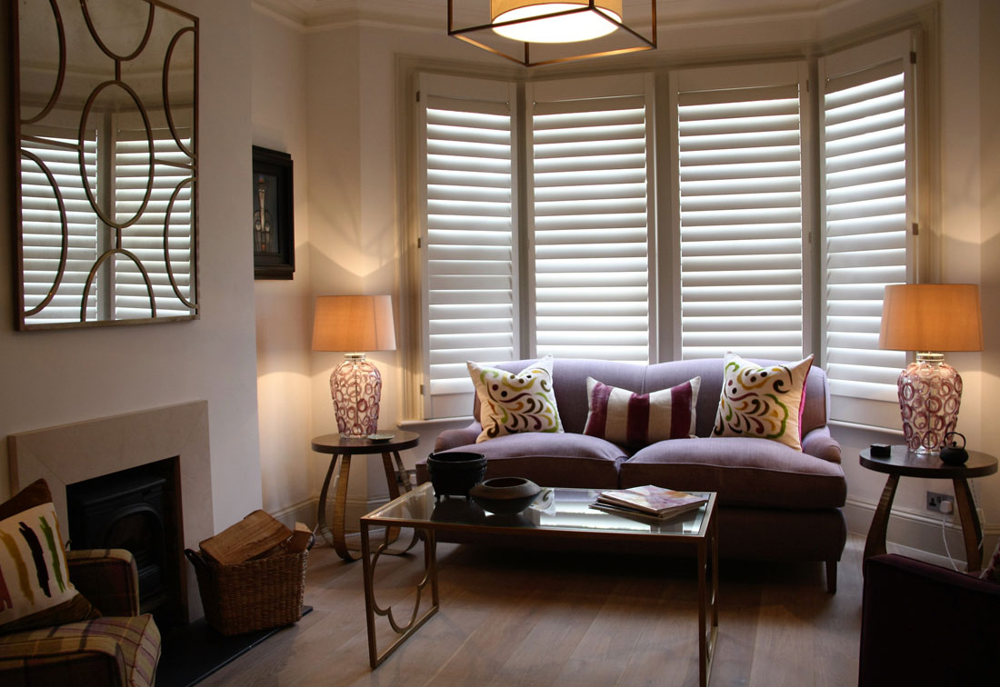 West Putney sitting room with purple sofa, patterned cushions and modern blinds by interior designer Suzi Searle