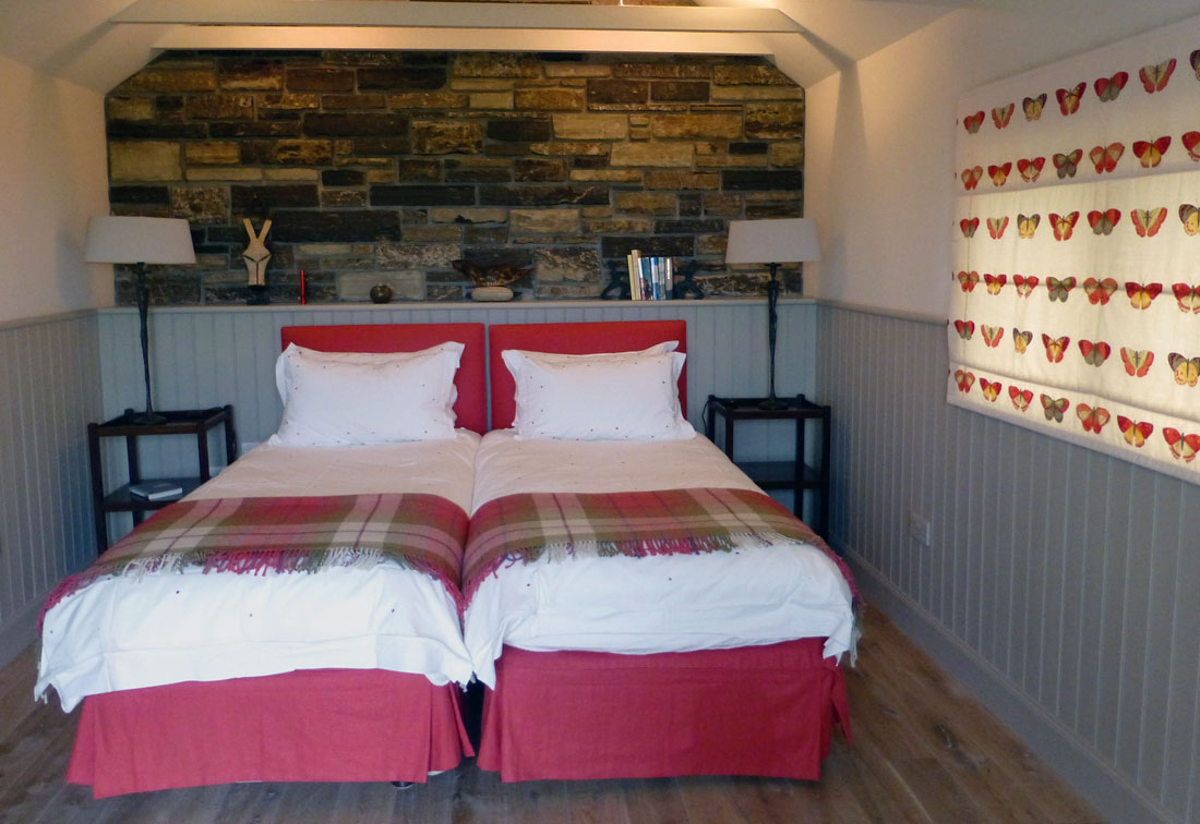 Guest bedroom in home in Orkney with red and grey colour scheme - part of a project by London interior designer Suzi Searle