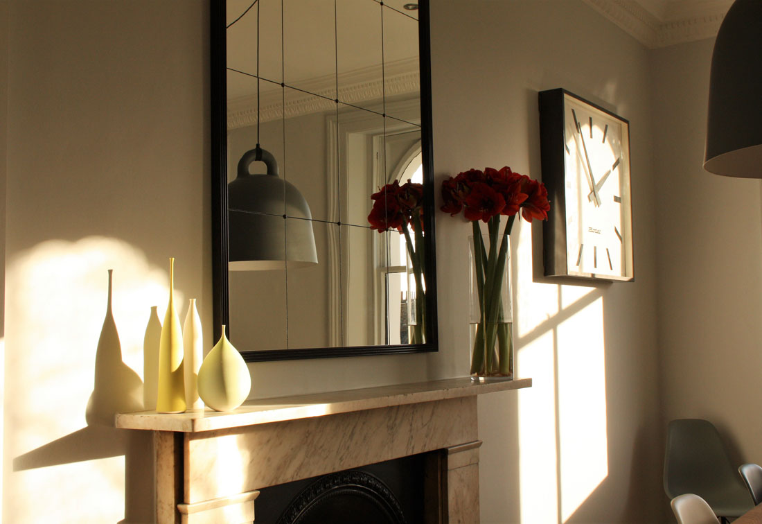Contemporary interior design in Notting Hill with a fireplace and clock, by interior designer Suzi Searle